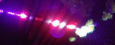 Blue violet laser pointer shining across uv reactive carpet sample.jpg